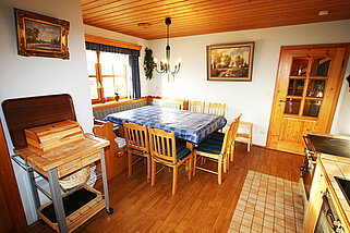 Tisch mit Brotkasten, Essgruppe und zwei schönen Gemälden