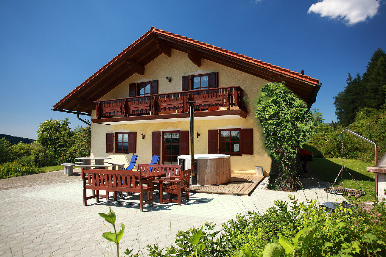 Vorderansicht des Hauses im Sommer mit Tischgarnitur