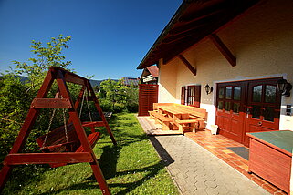Seitliche Ansicht mit Schaukel, Terrasse und Sitzbank
