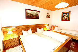 Fünftes Schlafzimmer mit Doppelbett und einem Einzelbett mit Nachtkästchen.