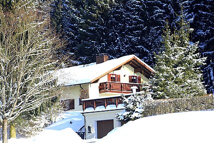 Ansicht des Hauses im Winter mit Zufahrt und Garage