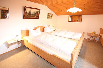 Zweites Schlafzimmer mit großen Bett und Gemälden im Hintergrund